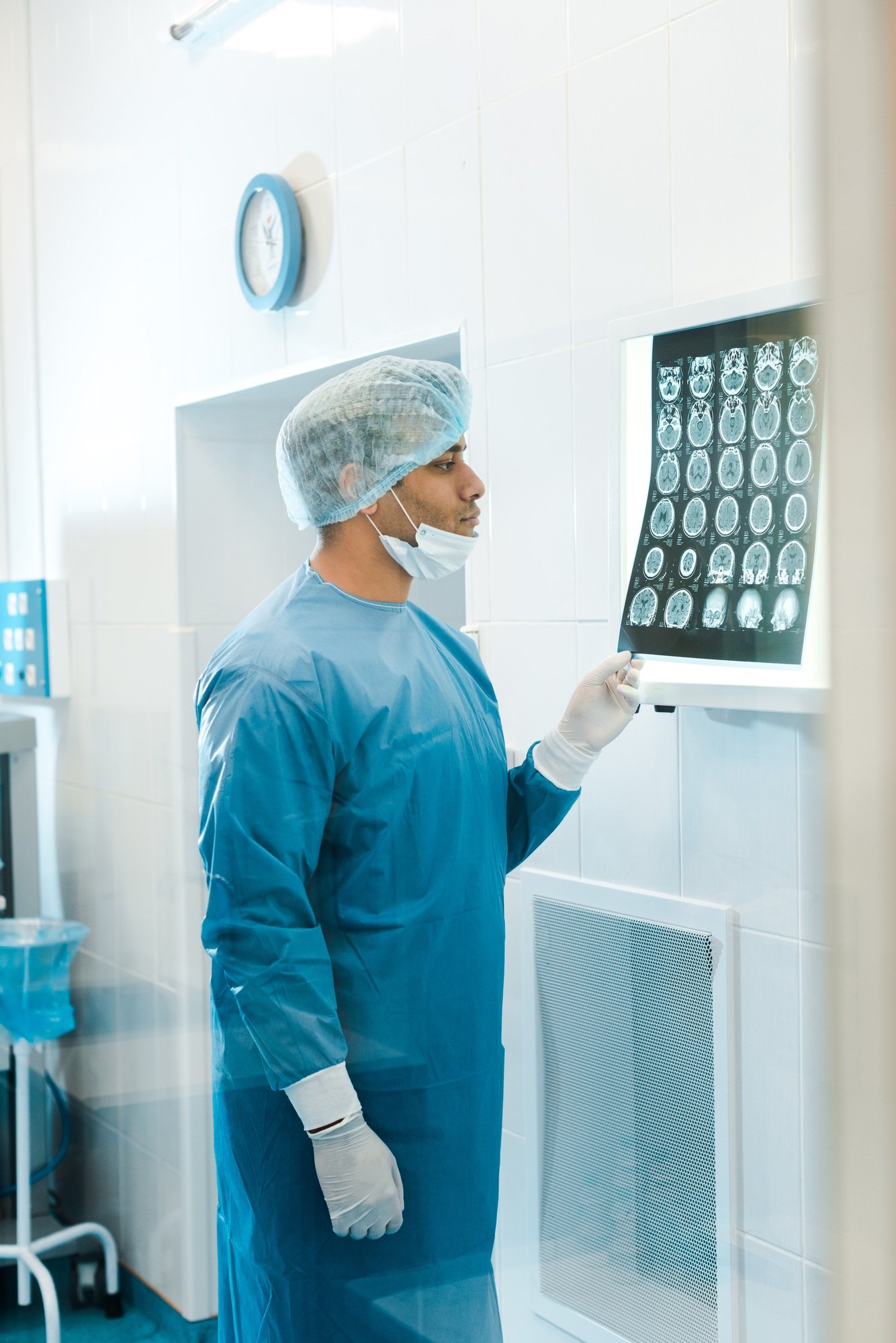 handsome doctor in uniform and medical mask holding x-ray in clinic